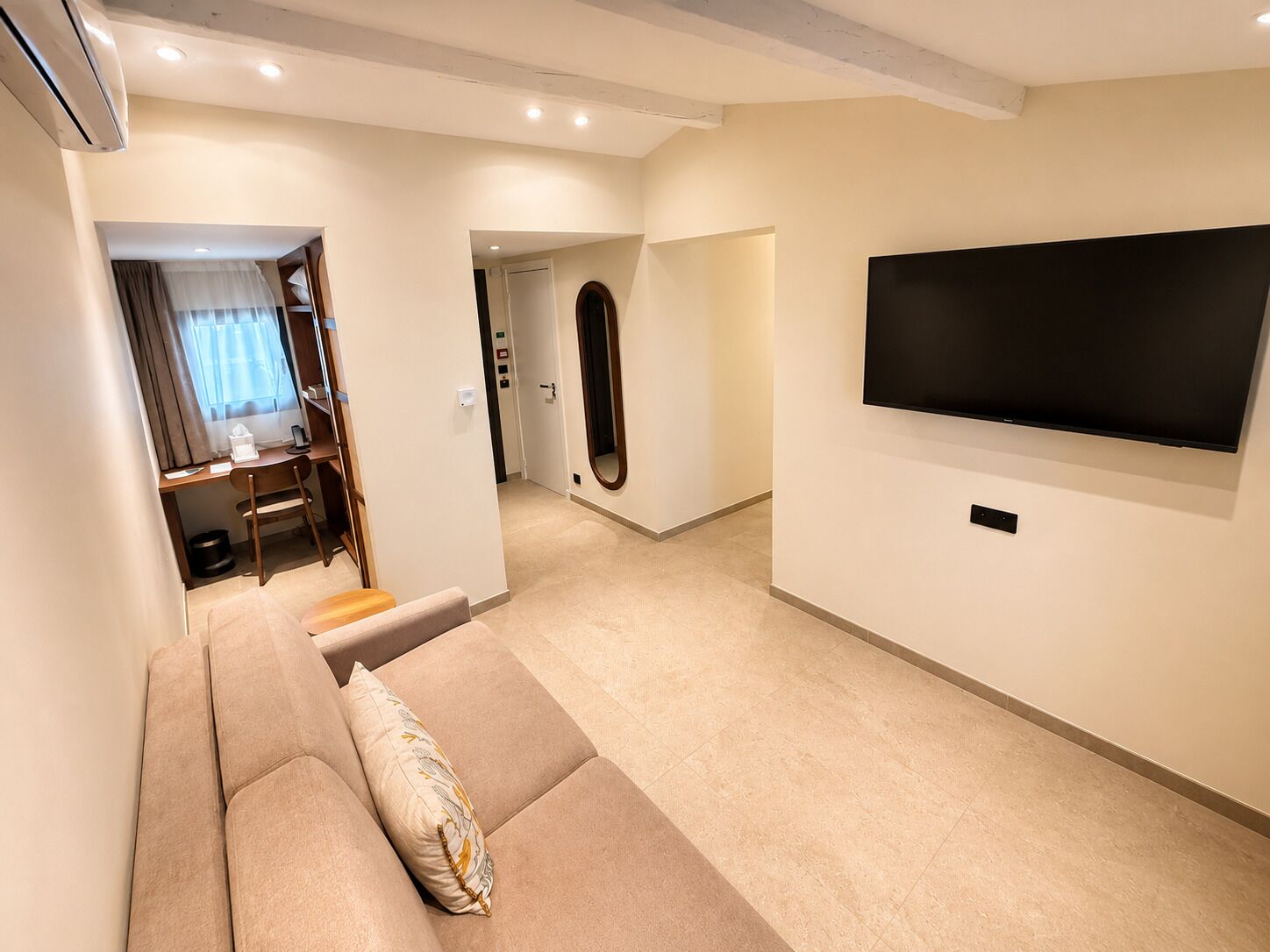A living room with a sofa, a TV, and a dining area with a table and chairs.