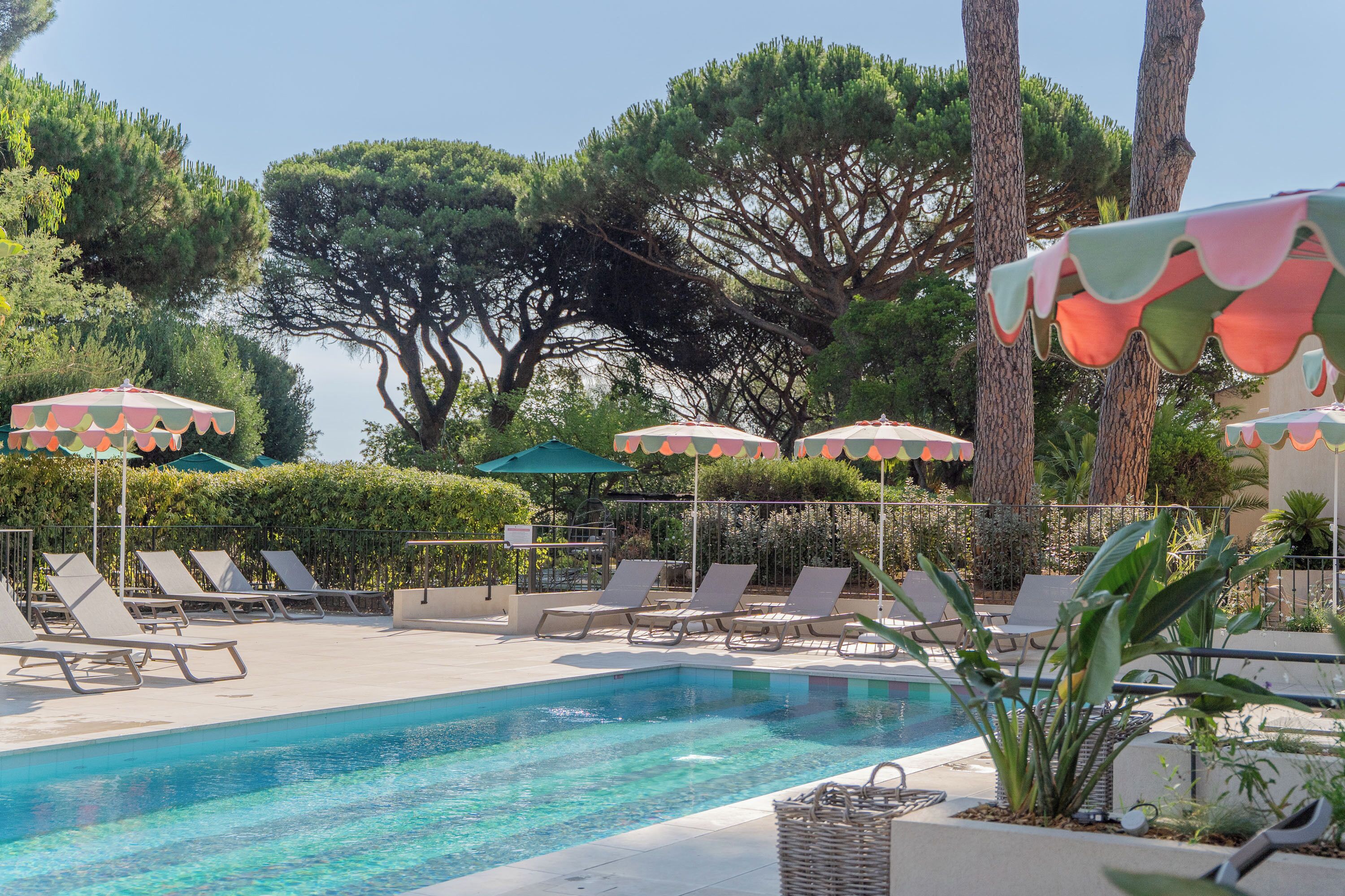 A pool area with lounge chairs and umbrellas.
