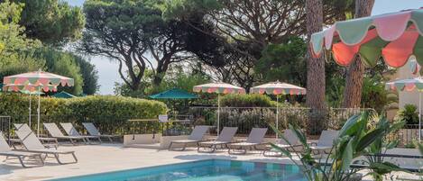A pool area with lounge chairs and umbrellas.