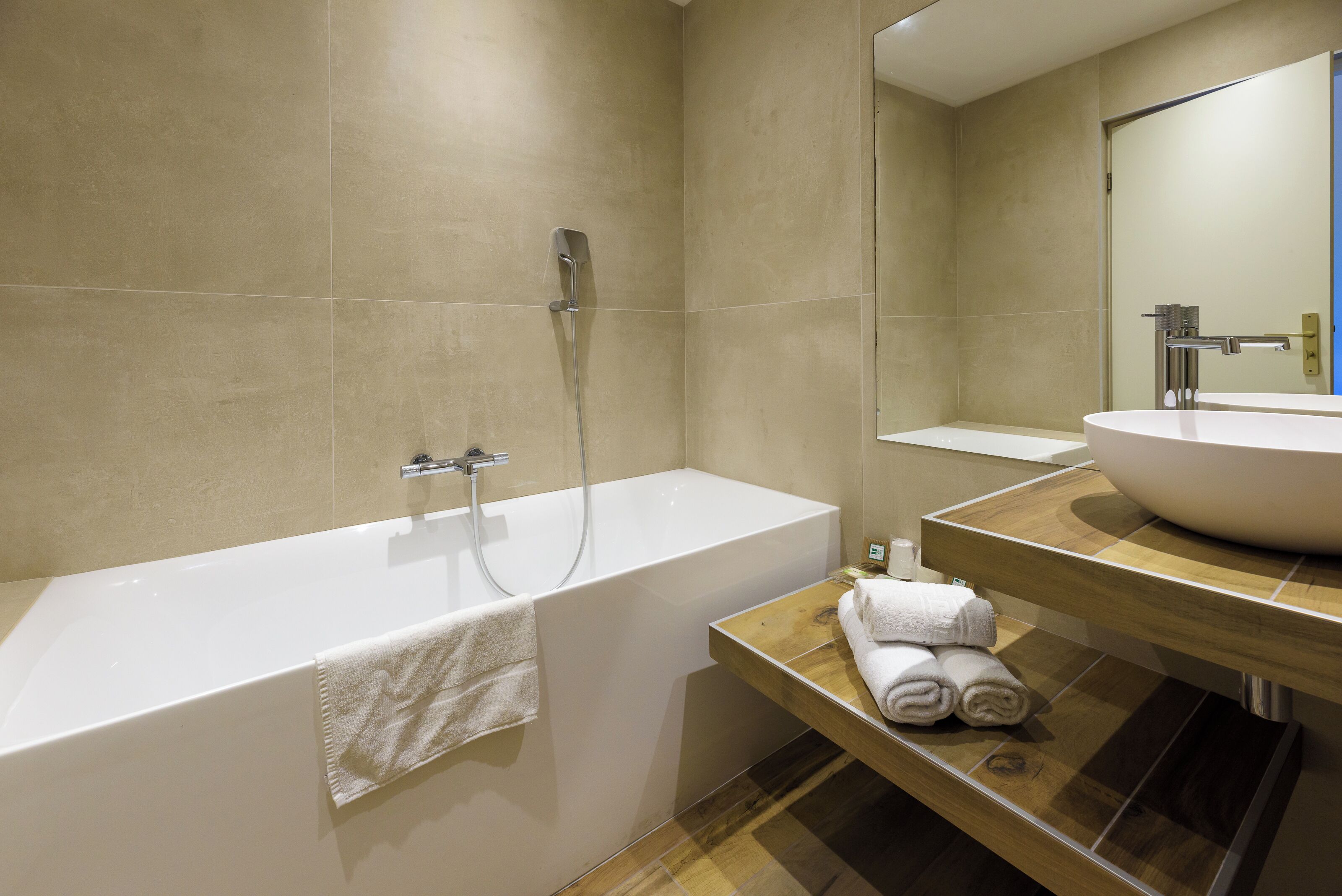 Un baño moderno con una bañera, un lavabo y un espejo.