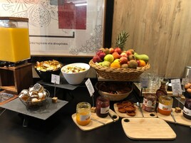 A breakfast buffet with various food items, including fruits, honey, and jams.