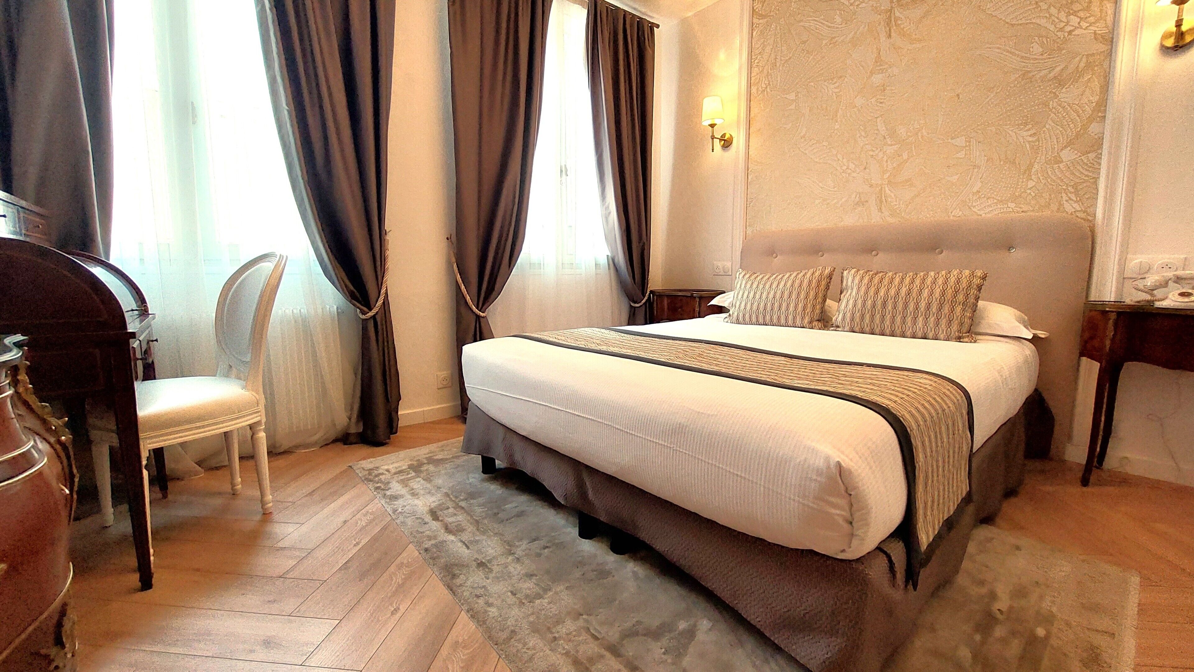 Une chambre à coucher avec un lit, une chaise, une table de chevet et une lampe.