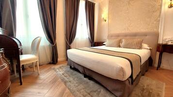 Une chambre à coucher avec un lit, une chaise, une table de chevet et une lampe.