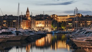 A marina with boats docked, a clock tower, and illuminated buildings. - Escale Oceania Marseille Vieux Port (Marseille)