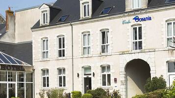 A hotel with a classic facade, multiple windows, and a central archway.