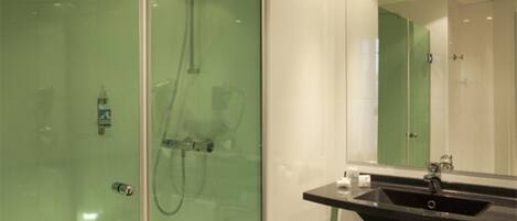 Un baño moderno con cabina de ducha de vidrio, un lavabo negro y un espejo grande.