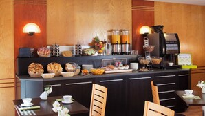 A breakfast bar with various food items, a coffee machine, and seating arrangements. - Escale Oceania Vannes (Vannes)