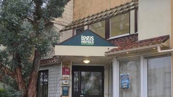 Ein Gebäude mit einem Schild für 'Logis Hotels Restaurants' am Eingang.