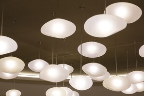 Multiple hanging pendant lights with a white shade.