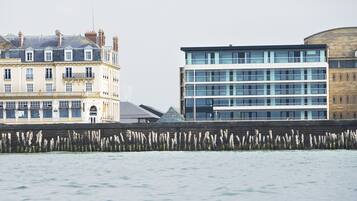 A waterfront view with a historic building and a modern structure.