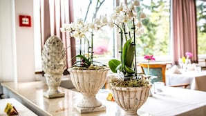 A table with potted orchids and a decorative urn. - VitalHotel Ascona (Bad Bevensen)