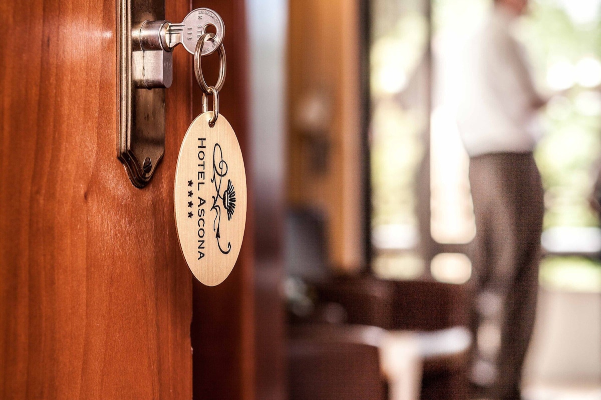 A hotel room door with a keycard holder displaying the name "Hotel Ascona".