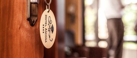 A hotel room door with a keycard holder displaying the name "Hotel Ascona".