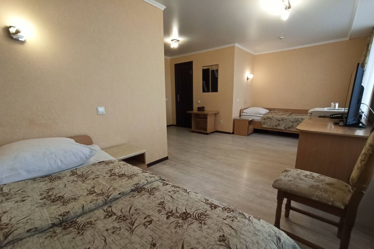 Una habitación de hotel con una cama, un escritorio, una silla y una mesita.
