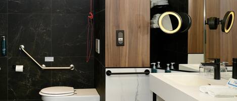 A modern bathroom with a toilet, sink, and mirror.