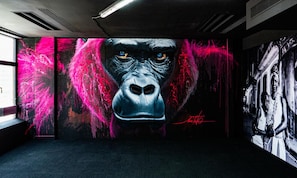 A room with a large gorilla mural, a black and white photo on the wall, and a visible window. - Hilton Paris La Defense Hotel (Puteaux)