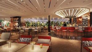Un ristorante moderno con zona bar, tavoli e sedie rotonde, e un soffitto con un lampadario particolare.