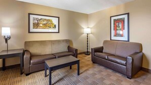 A hotel room with two sofas, a small table, and two lamps. - Extended Stay America Suites Great Falls Missouri River (Great Falls)