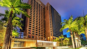 Um hotel moderno com muitos andares, design arquitetônico contemporâneo e área de entrada bem iluminada.