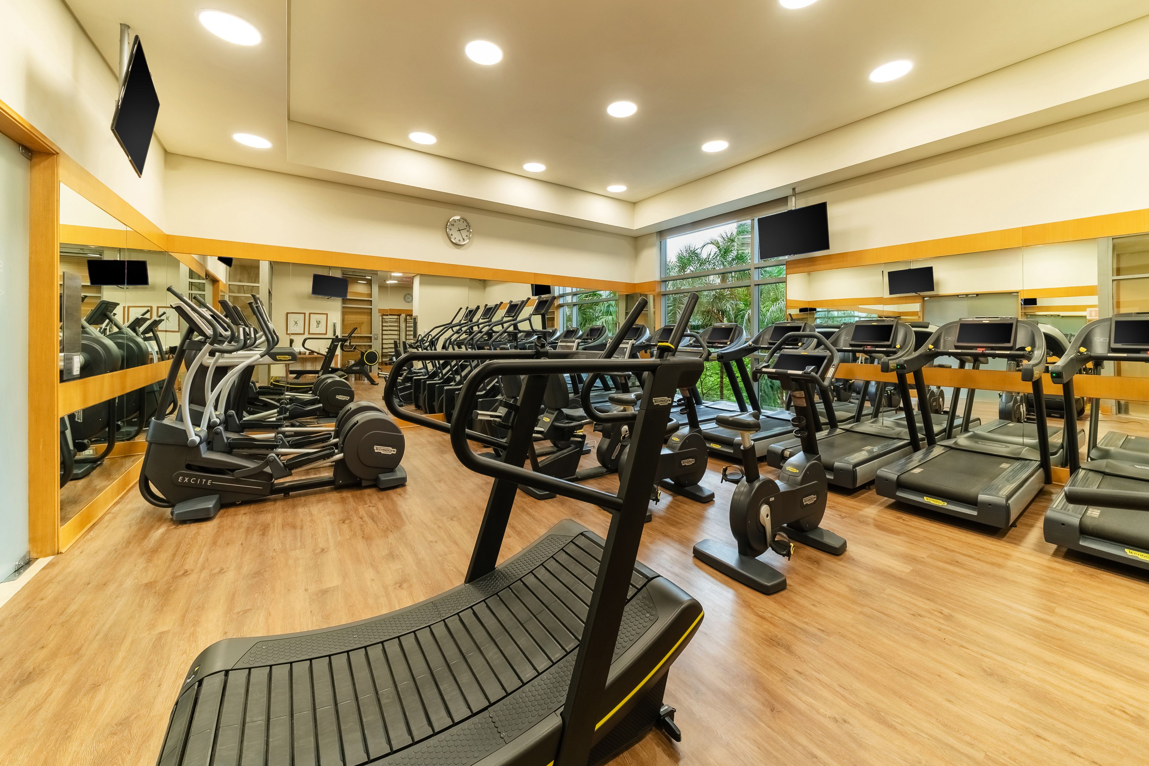 Academia com esteiras, elípticos e máquinas de musculação.