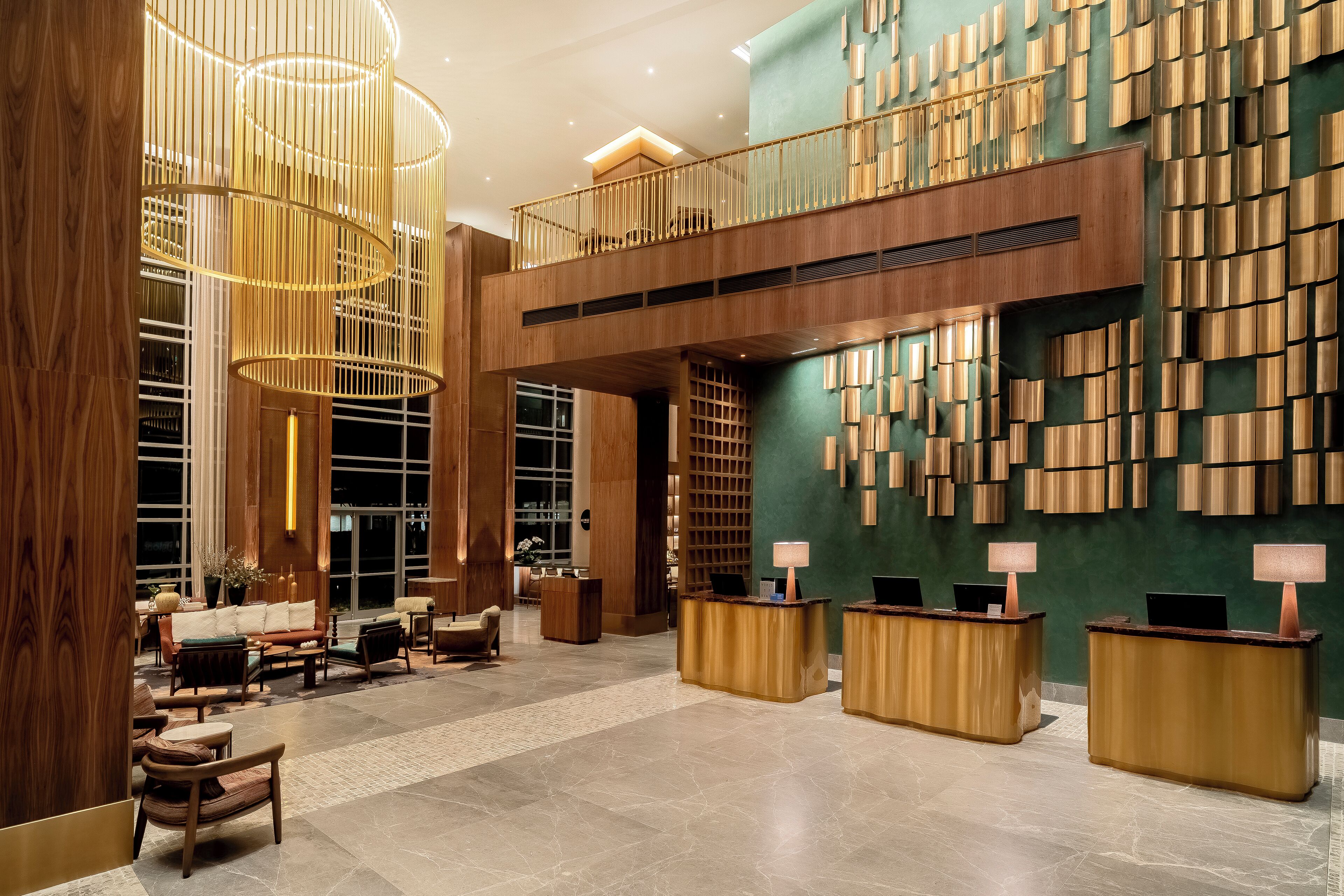 A spacious lobby with a reception desk, seating area, and a decorative wall with vertical wooden panels.