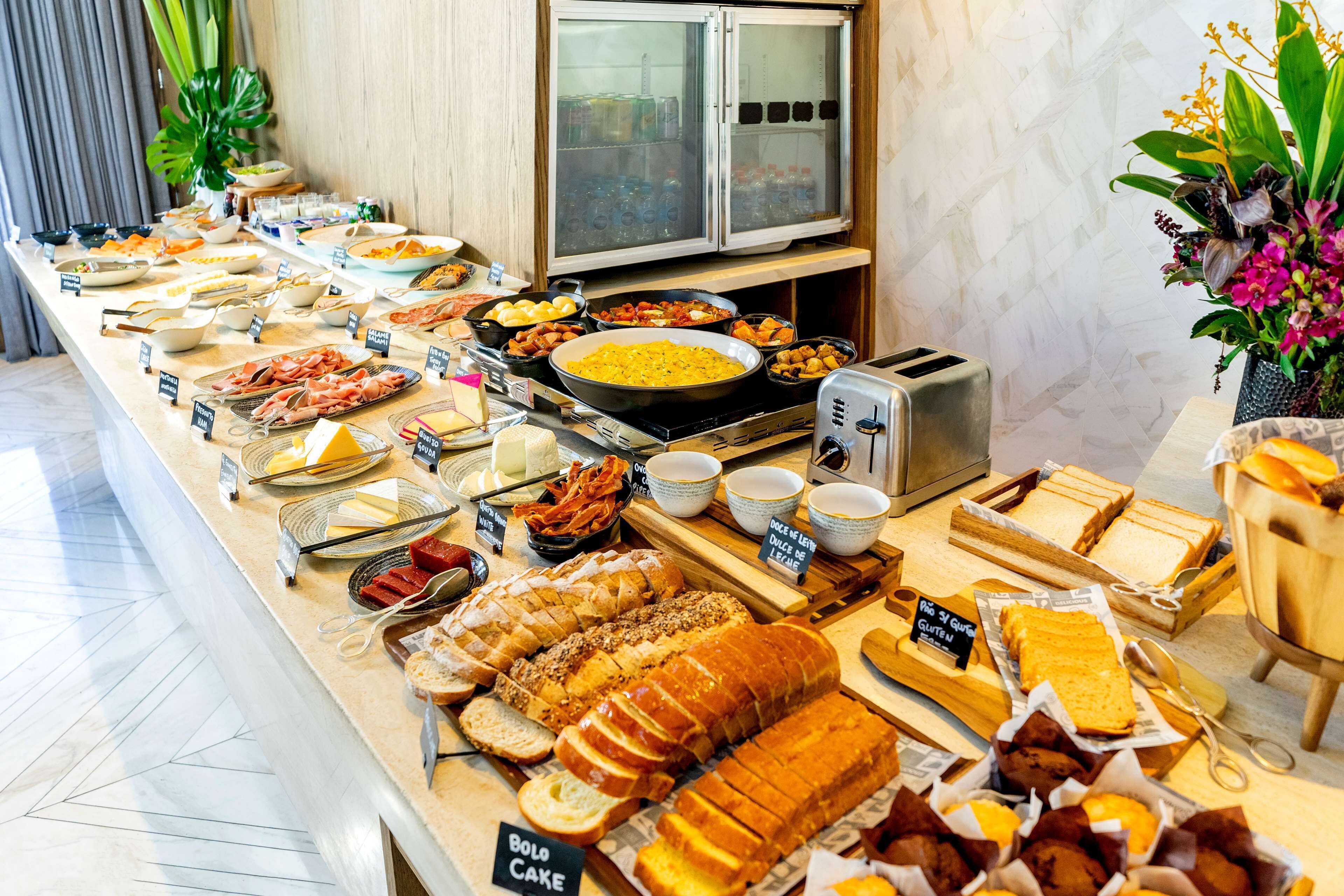 A buffet with various food items including bread, cheese, and meats.
