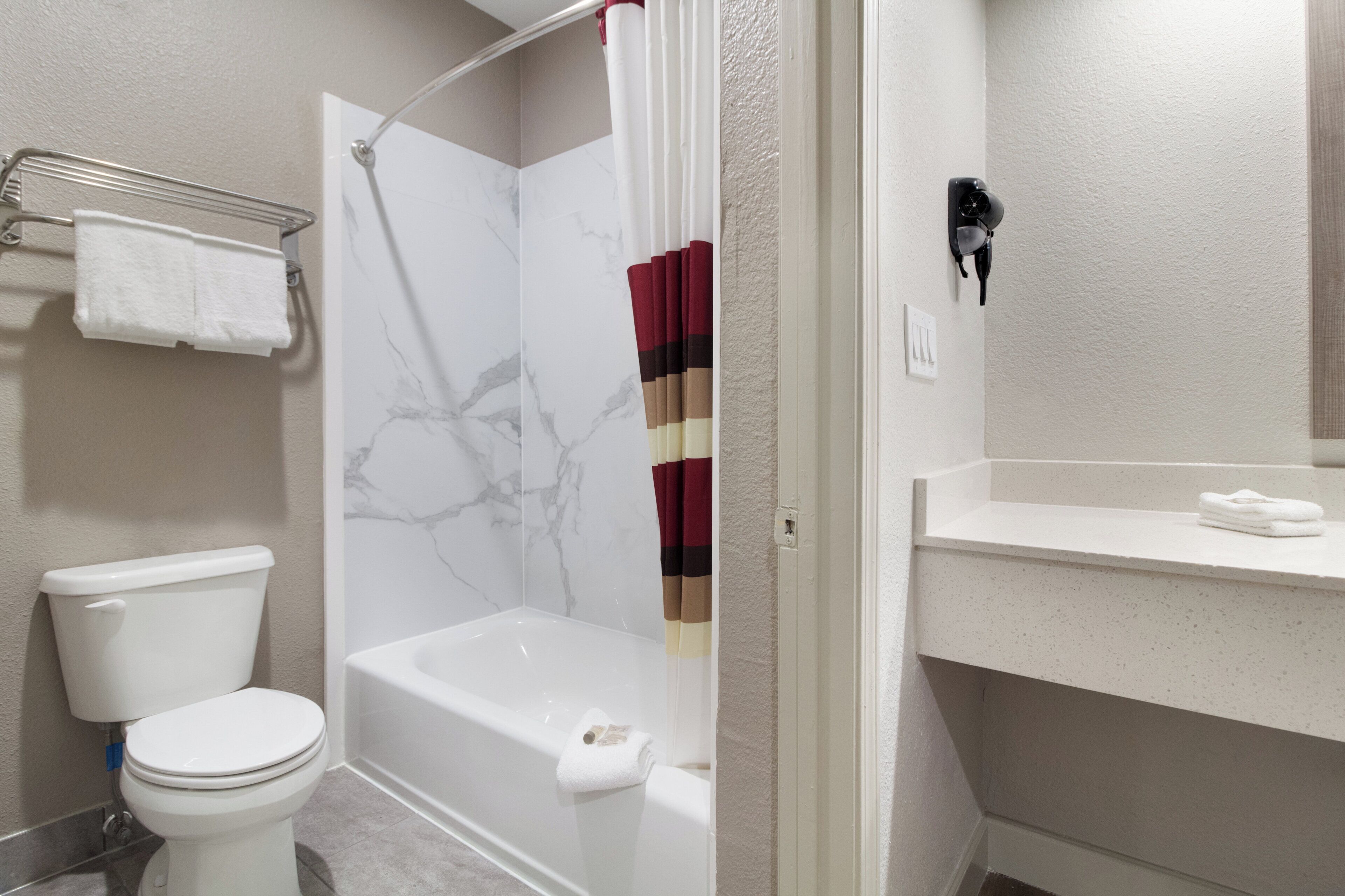 A bathroom with a toilet, a bathtub, and a shower curtain.