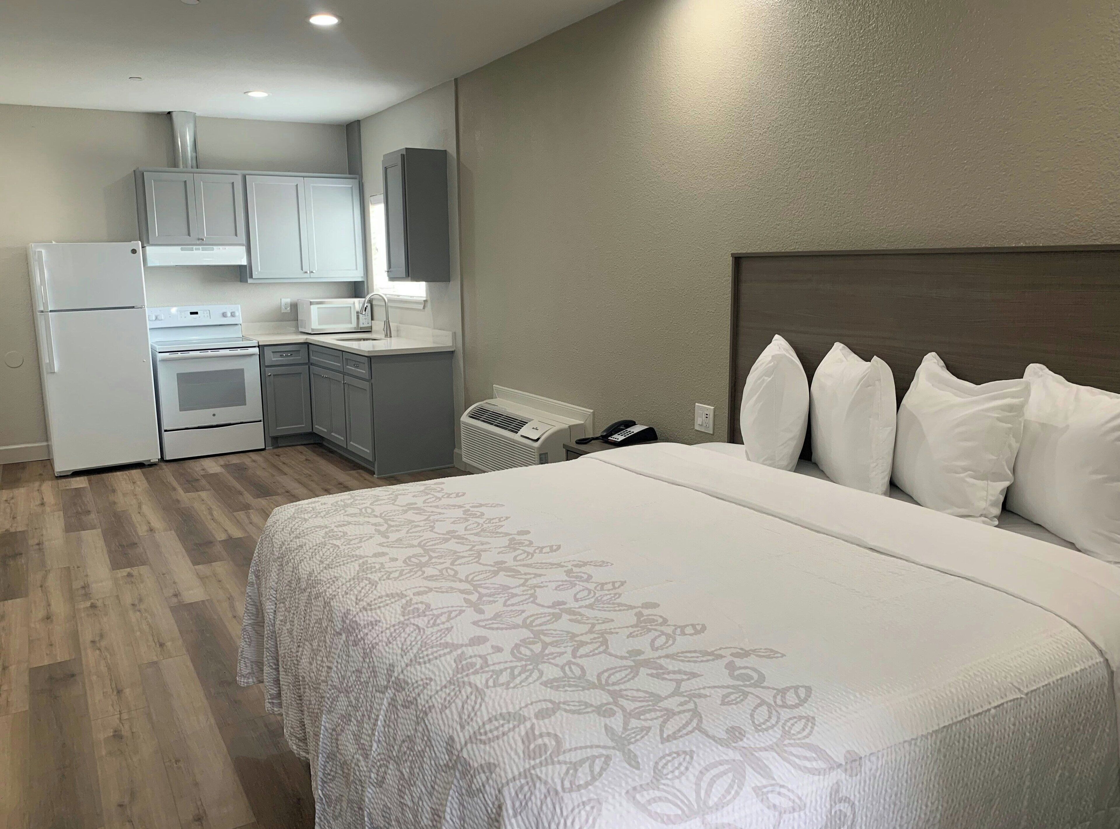 Une chambre d’hôtel comprenant un lit, une kitchenette et une salle de bain.