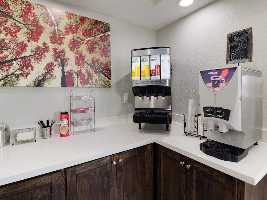 A coffee station with a Nescafé machine, a water dispenser, and a juice dispenser.