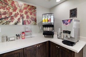 A coffee station with a Nescafé machine, a water dispenser, and a juice dispenser. - Red Roof Inn PLUS+ Galveston - Beachfront (Galveston)