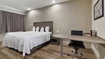A hotel room with a bed, a desk, and a chair.