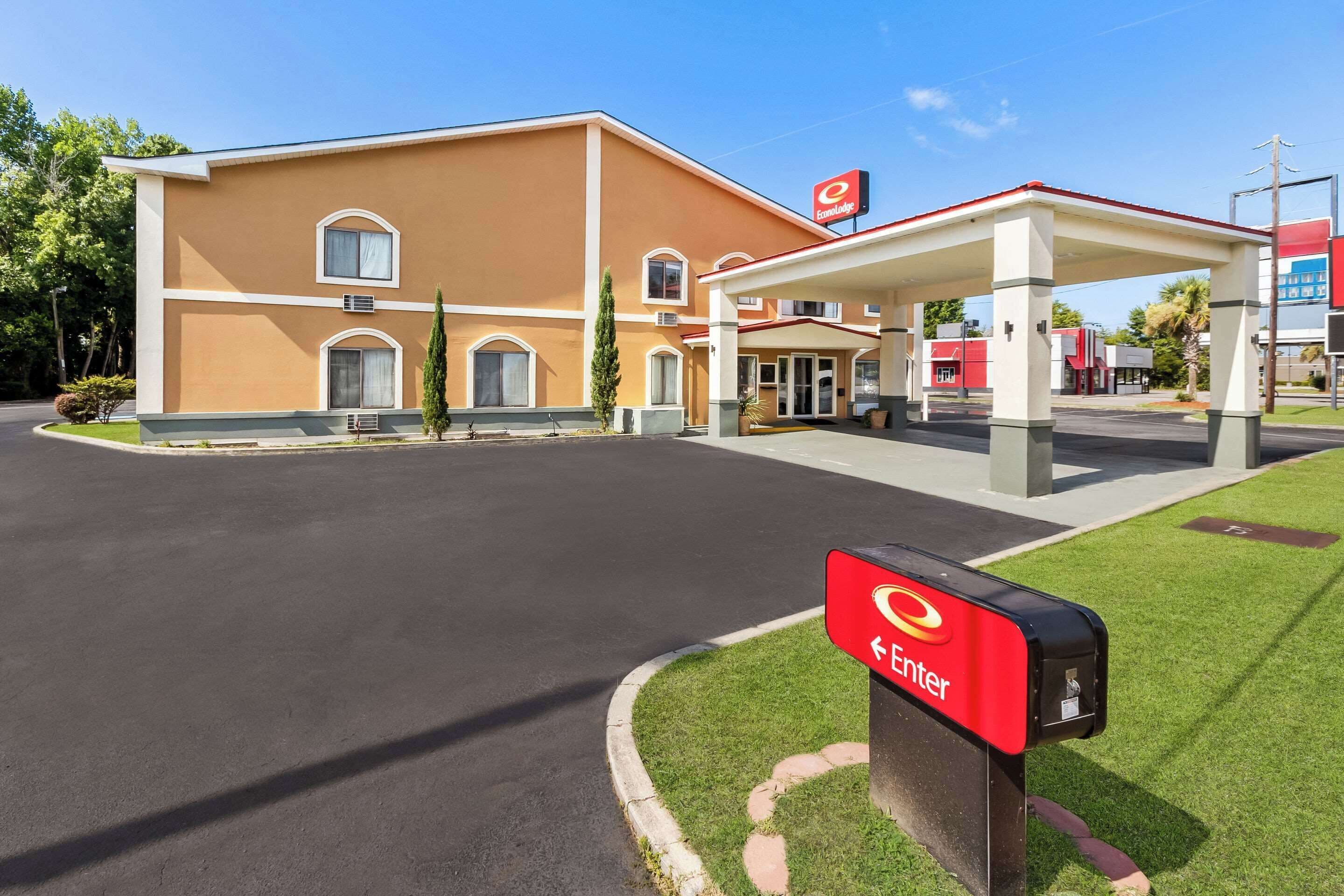 A hotel with a gas station, a red mailbox, and a clear sky.