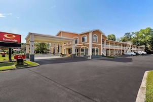 A two-story hotel with a covered entrance and a parking lot.