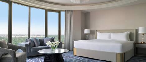 Une chambre d’hôtel avec un grand lit, un canapé, une table basse et une vue sur l’extérieur.
