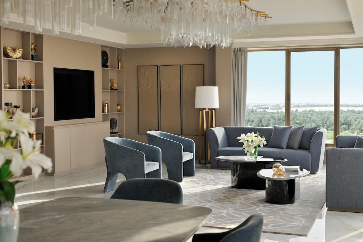 Una sala de estar moderna con un televisor grande, asientos cómodos y vistas al exterior.