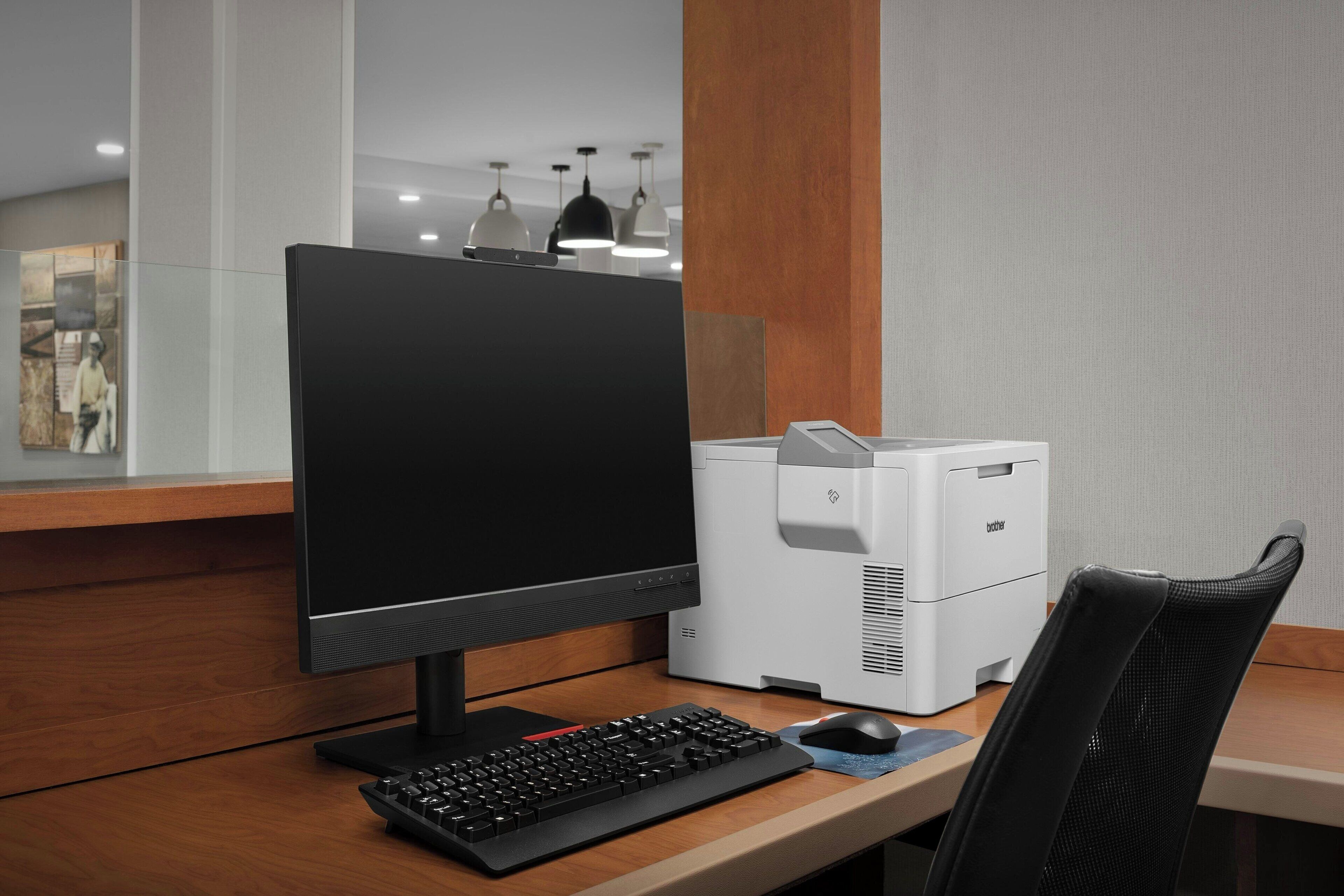 A modern office setup with a desktop computer, keyboard, and mouse on a wooden desk.