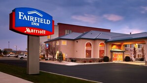 Een Fairfield Inn Marriott hotel met een modern design, met een groot bord, een goed verlichte ingang en een parkeerplaats.