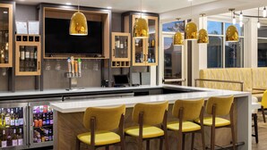 A modern bar area with a central island, bar stools, and pendant lighting. - Hilton Garden Inn Spokane Airport (Spokane)
