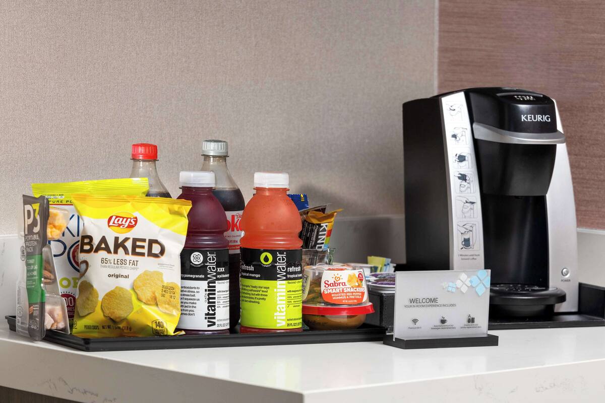 A minibar with snacks, beverages, and a Keurig coffee maker.