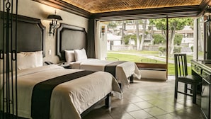 Une chambre d’hôtel avec deux lits, un bureau et une vue sur l’extérieur.
