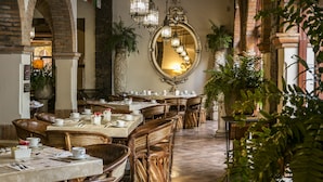 Un restaurant doté d’arches en briques, de meubles en osier et de lustres suspendus.