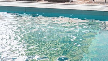 Una piscina techada, sillones reclinables de piscina