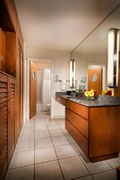 A modern bathroom with a wooden vanity, a large mirror, and a shower area.
