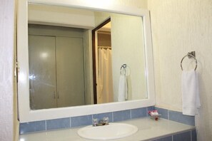 A bathroom with a large mirror, a sink, and a towel rack. - Hotel Casa Real Zacatecas (Guadalupe)