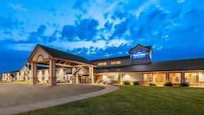 A hotel with a covered entrance, multiple rooms, and a well-lit facade. - Americinn By Wyndham Wabasha (Wabasha)