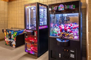 Three arcade machines with claw machines, one labeled 'Classic Cade' and another 'Toy House.' - Americinn By Wyndham Wabasha (Wabasha)