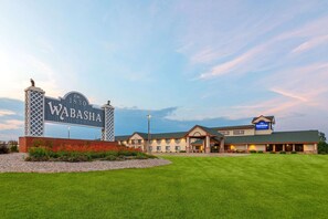 A hotel with a large sign reading 'WABASHIA EST. 1830,' a main building, and a smaller structure with an 'American Inn' sign. - Americinn By Wyndham Wabasha (Wabasha)