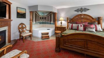 A bedroom with a large bed, a fireplace, a bathtub, and a view of a pool.