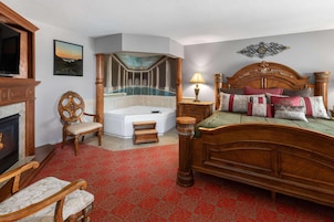Un dormitorio con una cama grande, chimenea, bañera y vistas a una piscina.