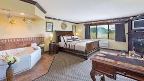 A bedroom with a large bed, a separate sitting area with a sofa, a desk, and a view of the outdoors. - Americinn By Wyndham Wabasha (Wabasha)